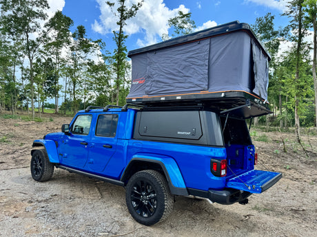 Blue Jeep Gladiator with Roofnest rooftop tent & SmartCap camper setup. Perfect for your next RV rental adventure.