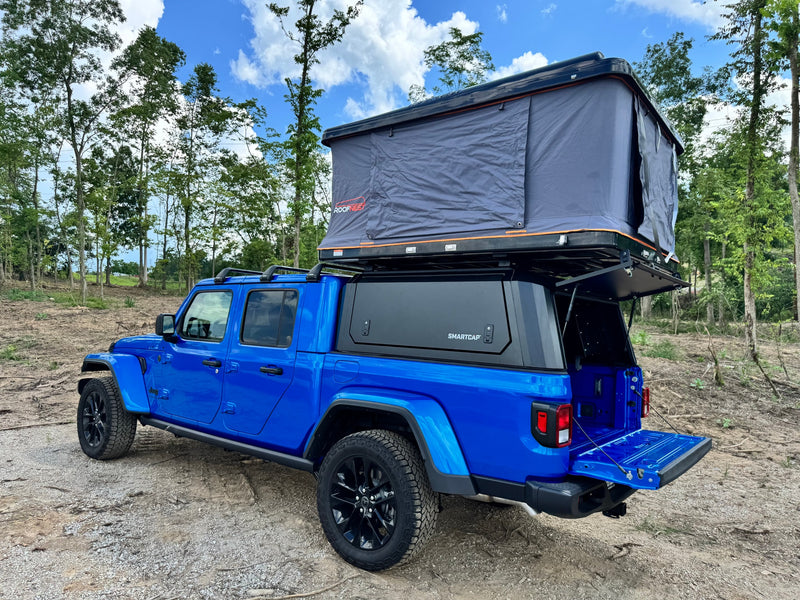  ideal for an RV rental or overlanding trip.|Blue Jeep Gladiator with Roofnest rooftop tent & SmartCap camper setup. Perfect for your next RV rental adventure.|Blue Jeep Gladiator with rooftop tent & bed cap for your next RV rental adventure.|This bright blue Jeep Gladiator — photo 7
