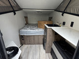  mounted on an RV over gravel.|This Clipper pop-up travel trailer
