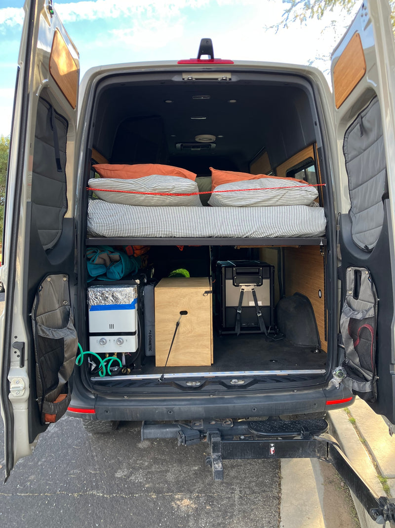  with sunbeams piercing through tall trees on a bright morning.|White Mercedes Sprinter RV rental parked in a wet — photo 15