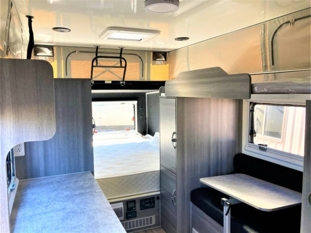  ready for your next adventure.|A white Ram pickup truck is towing a Dweller 15' travel trailer in a paved lot. A good look for an RV rental.|RV rental: Clean interior with sleek kitchenette — photo 11
