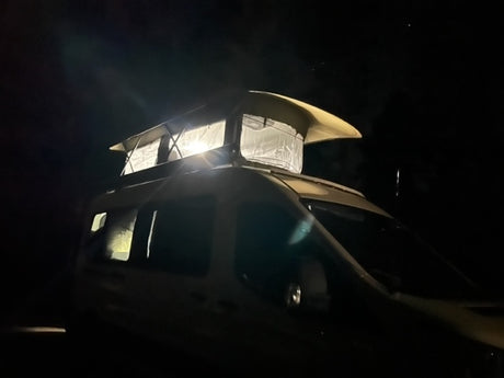 Night helicopter flight: Underslung equipment illuminated, a unique journey contrasting with an RV rental experience.