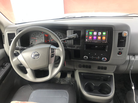 Inside a Nissan NV dashboard, showing the steering wheel, instrument cluster, and an aftermarket Sony Apple CarPlay unit, perfect for an rv rental.