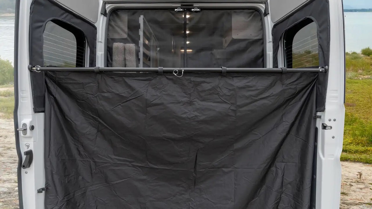 RV rental showing open rear doors with a black privacy screen, creating an outdoor changing room or shower. Ideal for camping.