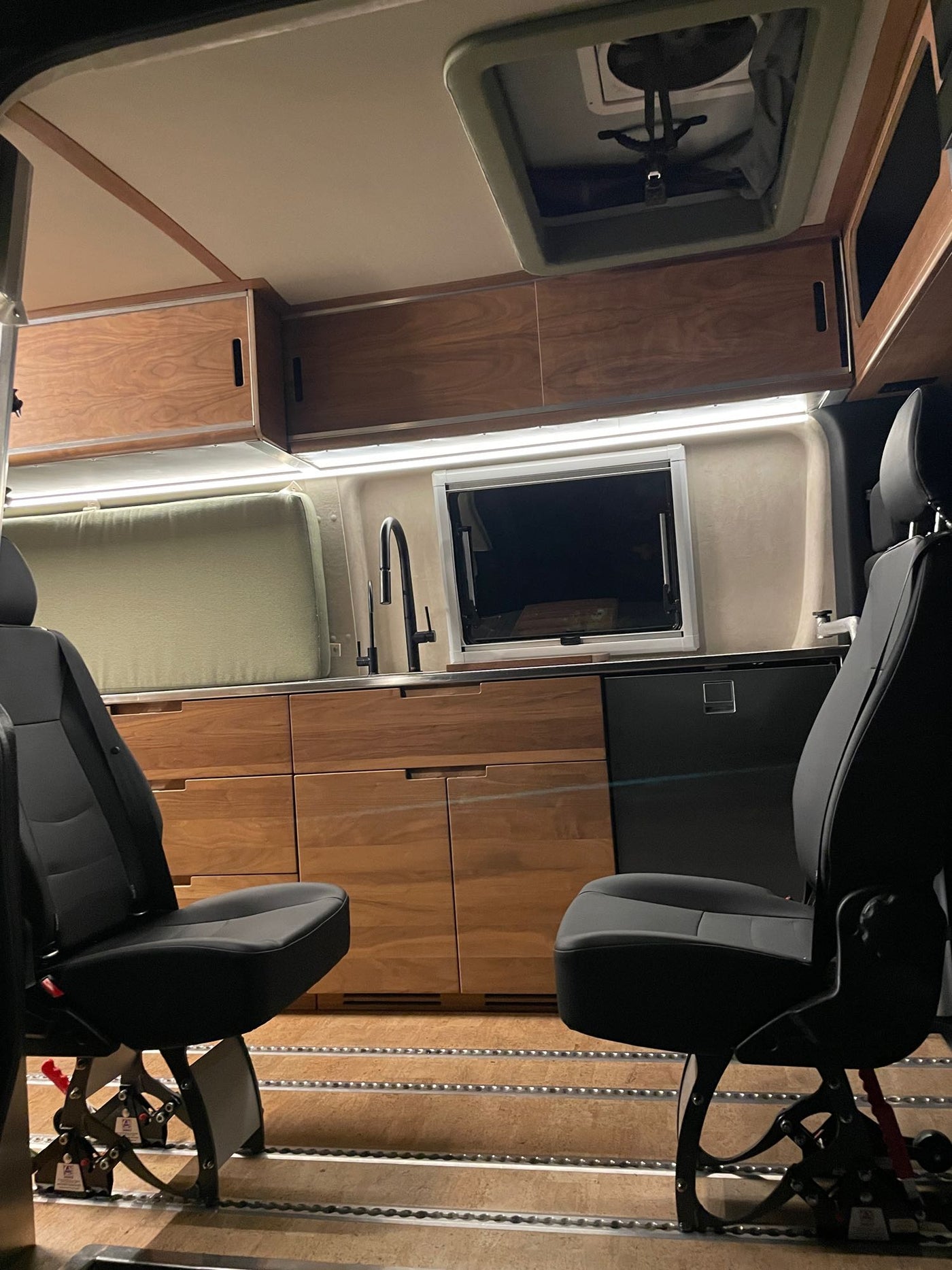  and street outside.|RV rental interior: A modern wooden kitchenette with a sink — photo 5