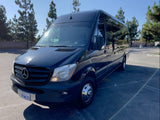 A sleek, black Mercedes-Benz Sprinter van, ready for rv rental, is parked on a sunny day. Ideal for group trips.