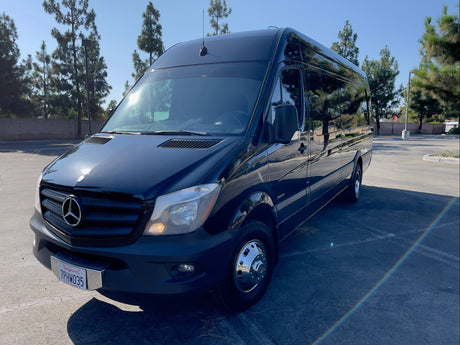 A sleek, black Mercedes-Benz Sprinter van, ready for rv rental, is parked on a sunny day. Ideal for group trips.