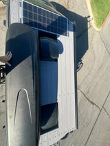 This RV rental roof shows a solar panel, black cargo box, and two vents on textured decking. Ready for travel!