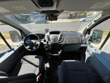 RV rental van interior: Driver's cockpit with Ford steering wheel, dashboard, and outside street view through the windshield.