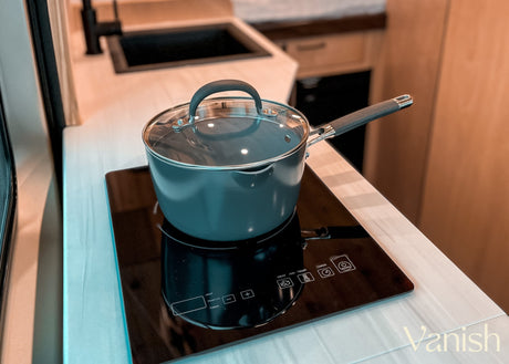Experience convenient cooking in an RV rental! Pot on an induction cooktop in a modern, compact camper kitchen.