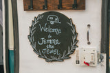 Personalized welcome sign 'Jemma the Jewel' on an RV rental door, with a lock and handle visible.