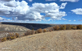 Scenic autumn landscape, ideal for an RV rental adventure. Rolling hills, big skies, and fall colors under bright clouds.