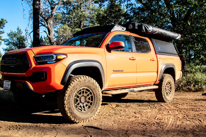 Red Toyota Tacoma with rooftop tent & awning setup for adventure. Perfect for your next overland rv rental trip!|Adventure-ready red Toyota Tacoma truck with an open rooftop tent and awning. An ideal RV rental for overlanding and truck camping.|Orange Tacoma overlander with pop-up tent & open bed storage in a sunny forest. Perfect RV rental alternative for adventure.|Vibrant orange Toyota Tacoma with an open rooftop tent — photo 9