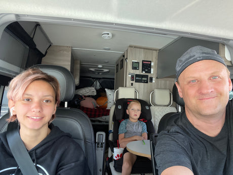 Family road trip in a comfortable RV rental. Parents and child relax inside their Winnebago camper van.