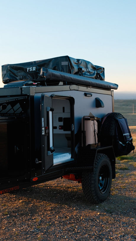 This rugged Boreas XT off-road camper trailer with an open door showing its interior is perfect for an RV rental adventure.