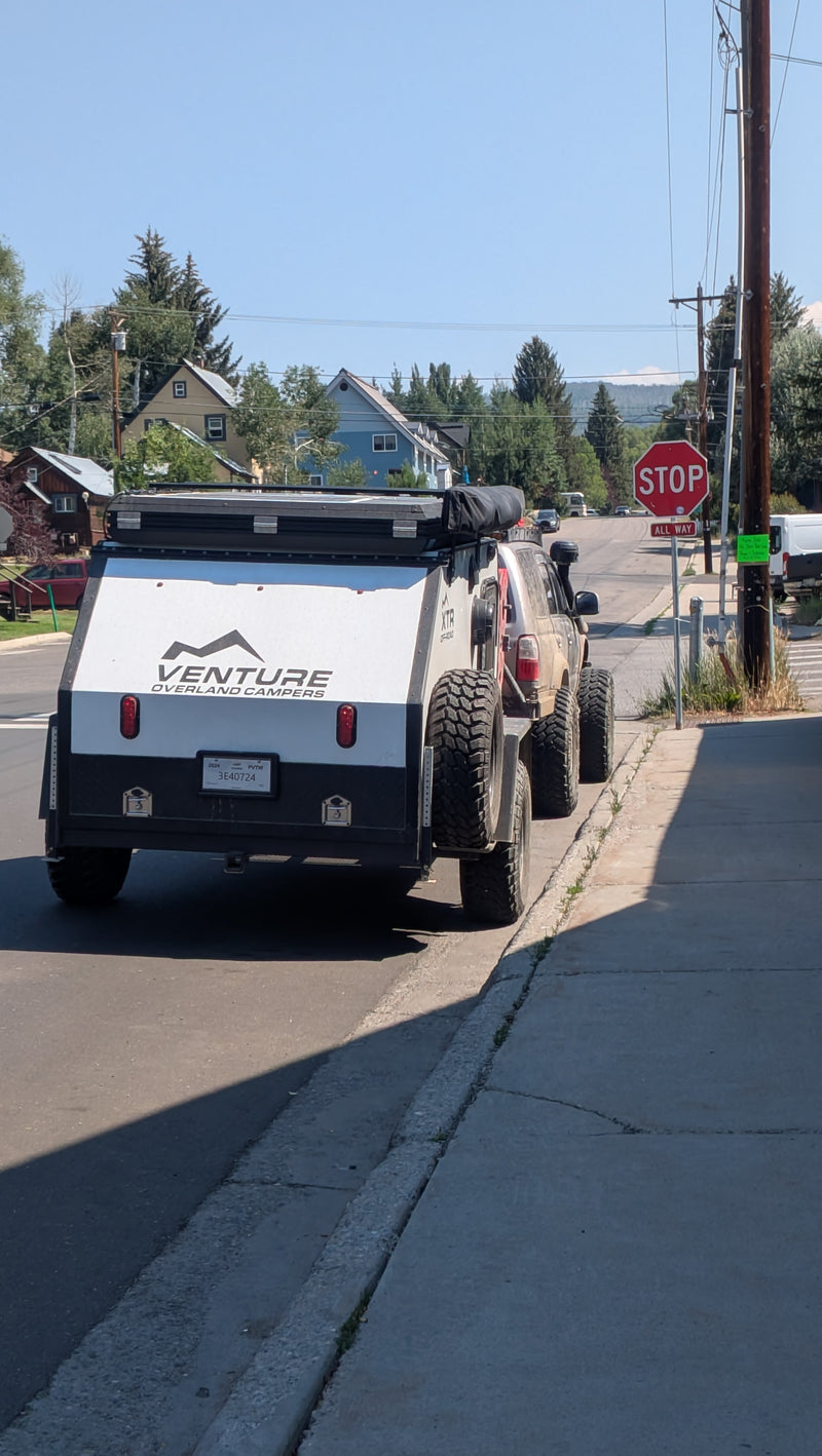 Overland camper (rv rental) & off-road SUV with Venture branding, parked on a street under a clear sky. — photo 19