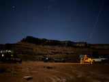 Starry desert night: Jeeps, truck w/ camper, & trailer w/ tent at an overland camp. Experience this adventure with an RV rental!