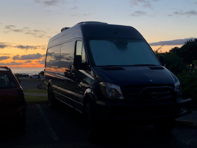 Coastal RV rental Sprinter van at sunset. Dark van silhouetted against a vibrant orange and blue ocean horizon. — photo 5