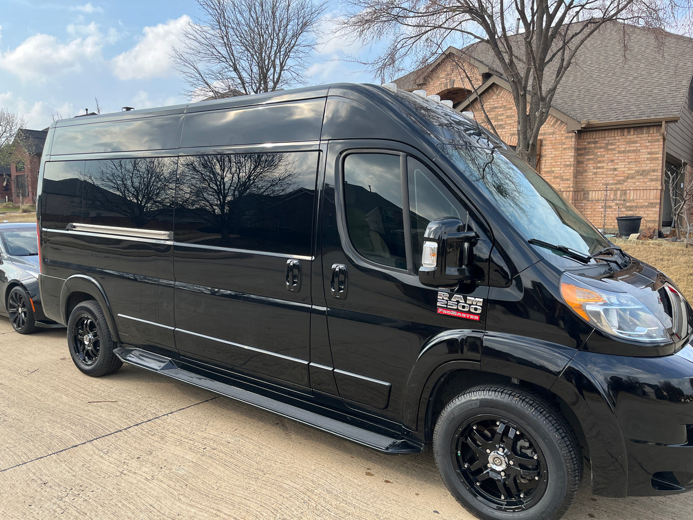 Black Ram 2500 ProMaster van, an excellent RV rental option, with custom wheels and running boards. — photo 9