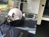 Enjoy an RV rental's functional mobile kitchen with induction cooktop, sink, and dish drying rack for convenient camping.