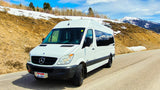White Mercedes-Benz Sprinter camper van (RV rental) on a snowy mountain road. Ready for your next outdoor adventure.