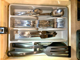 RV rental kitchen drawer showing a tidy utensil organizer with spoons, forks, knives, and serving tools.
