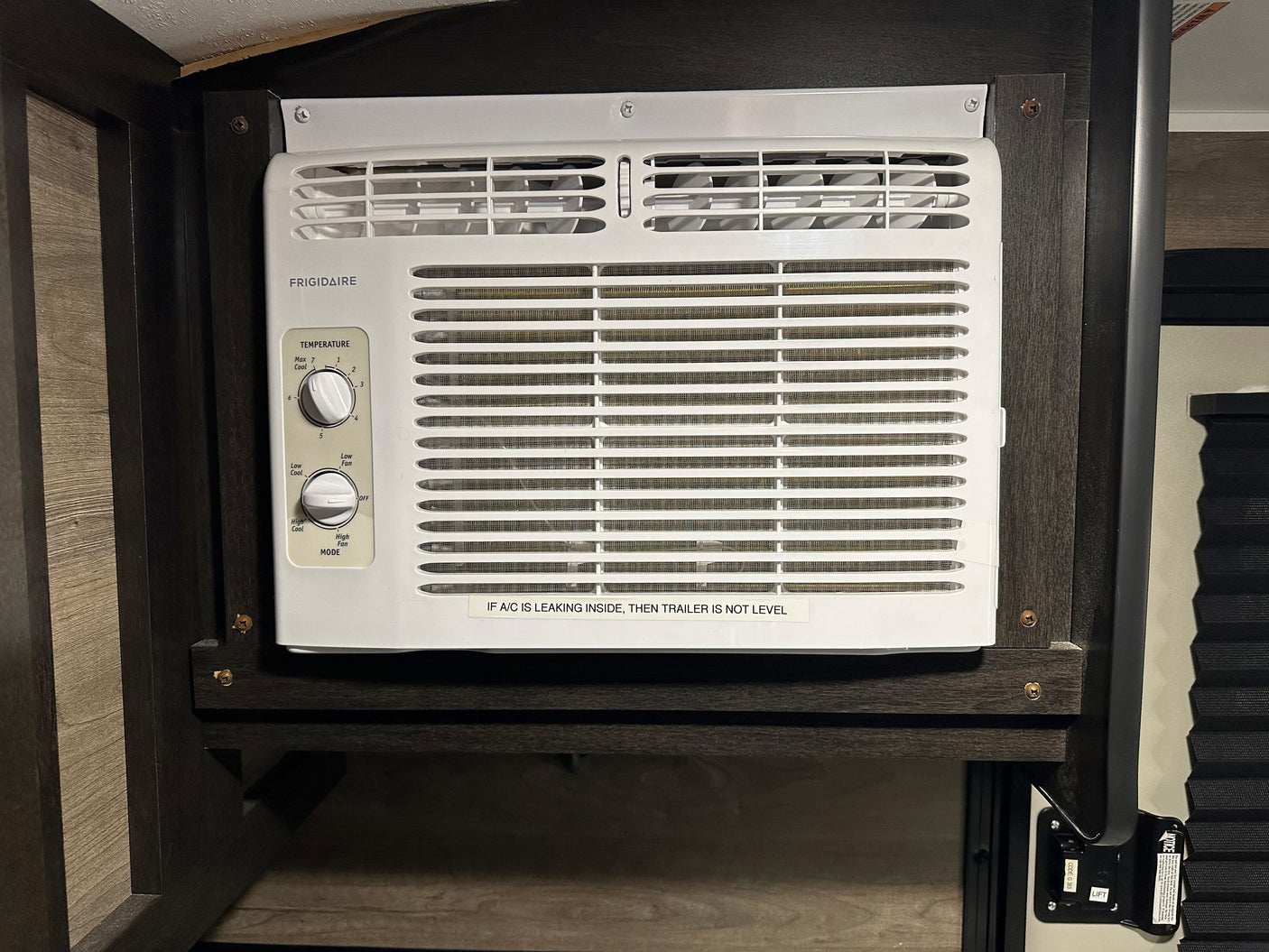 Frigidaire AC unit in an rv rental interior, with temperature controls and a 'leveling' warning sticker.