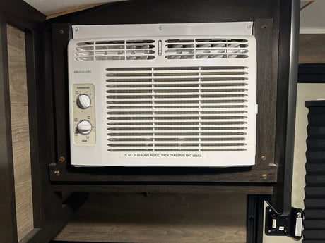 Frigidaire AC unit in an rv rental interior, with temperature controls and a 'leveling' warning sticker.