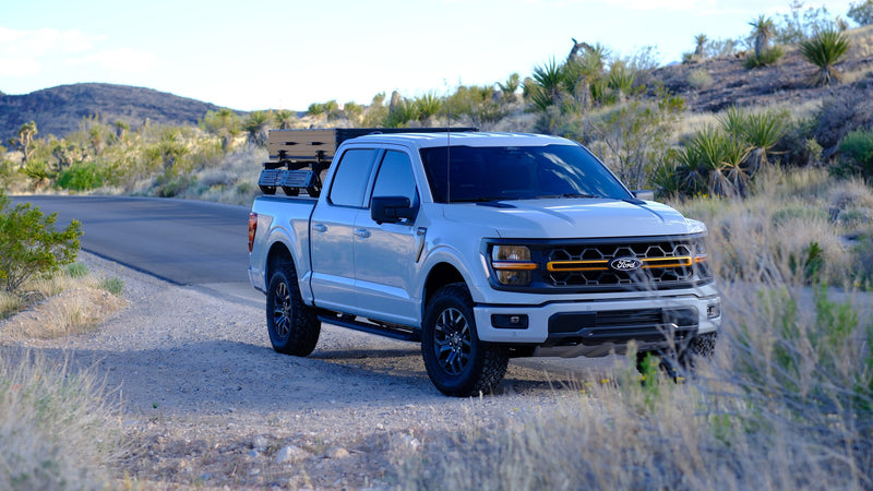 A white Ford F-150 pickup, loaded with overland gear, parked off-road in a desert landscape. Perfect for an rv rental adventure. — photo 4