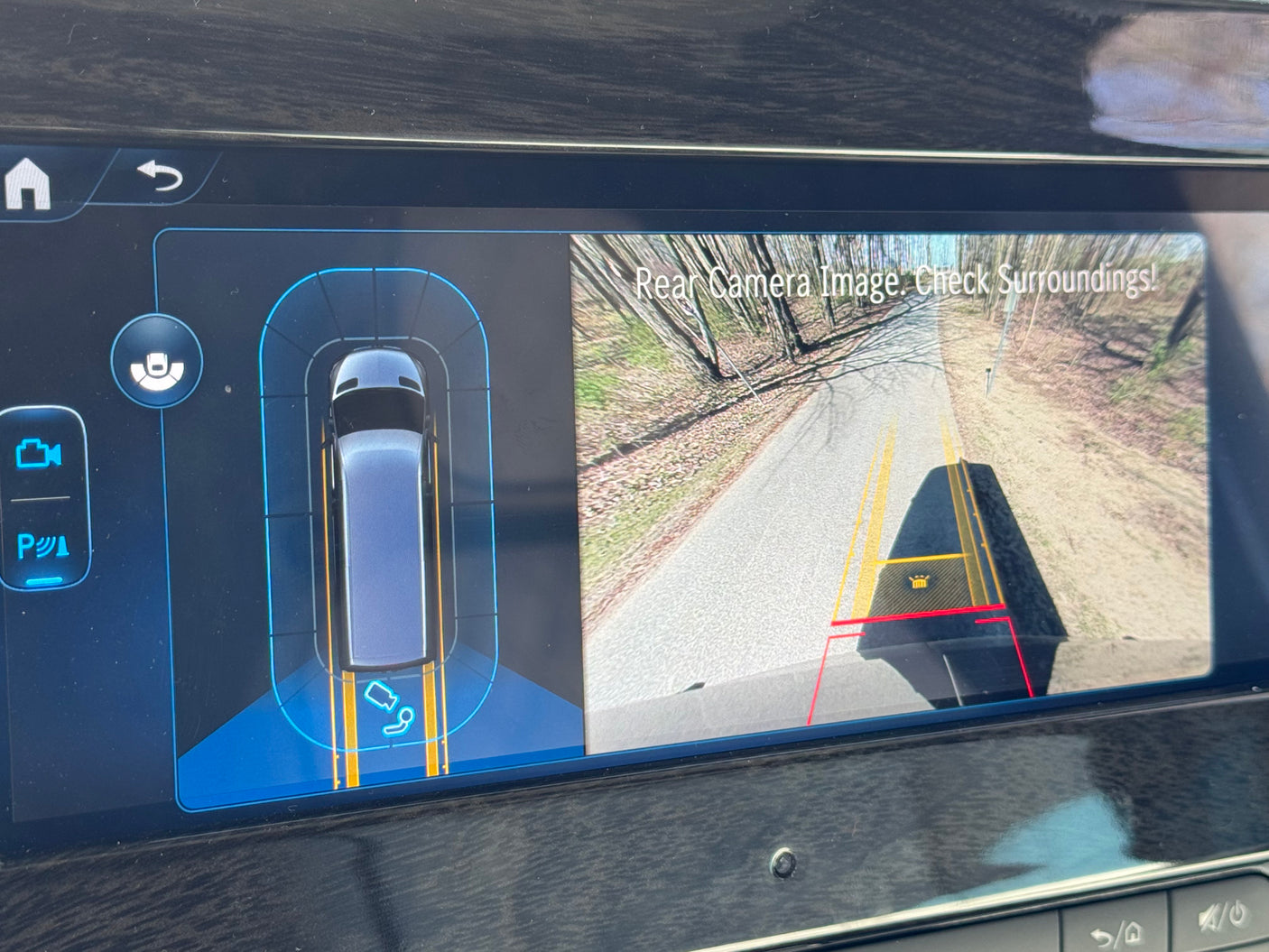 RV rental: Infotainment screen shows rear camera view with parking guidelines and an overhead vehicle display for parking assist.