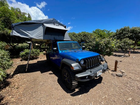 This blue Jeep with a Thule Tepui rooftop tent offers an RV rental experience for Hawaii outdoor camping.