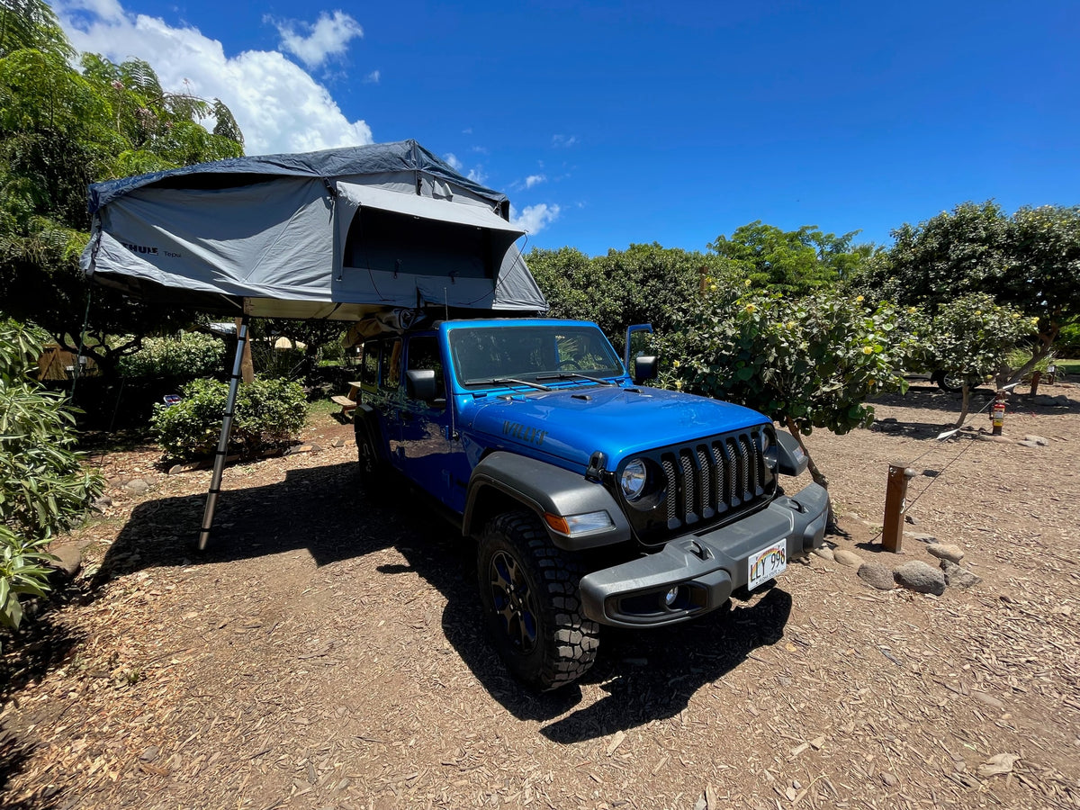 This blue Jeep with a Thule Tepui rooftop tent offers an RV rental experience for Hawaii outdoor camping.|Blue Jeep Wrangler with a rooftop tent — photo 21