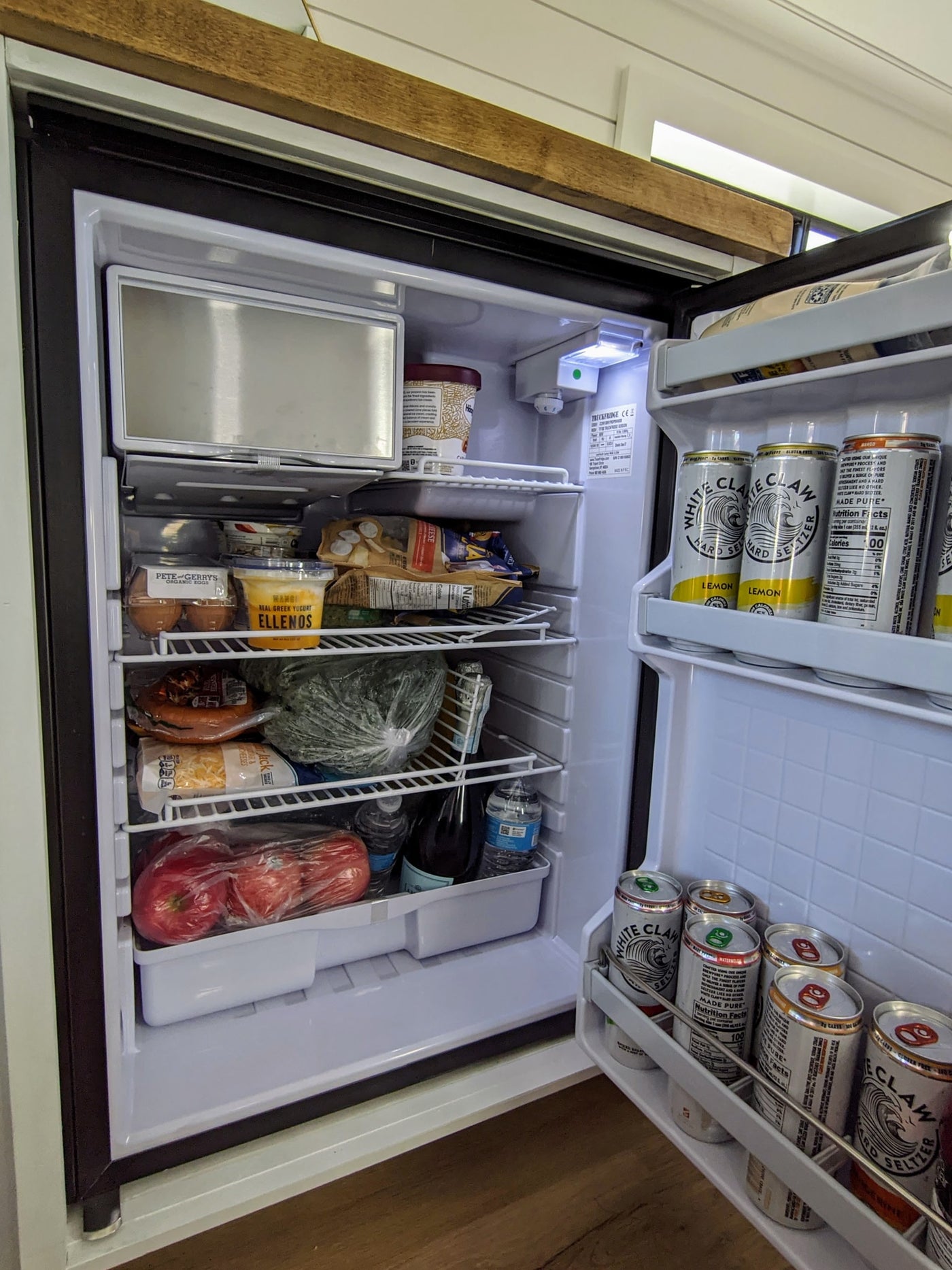 An RV rental refrigerator stocked with eggs, yogurt, produce, and White Claw seltzers for the trip. — photo 20