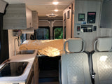 Modern Winnebago RV rental interior: galley, bed, and passenger seating, with visible control panels. Perfect mobile adventure.