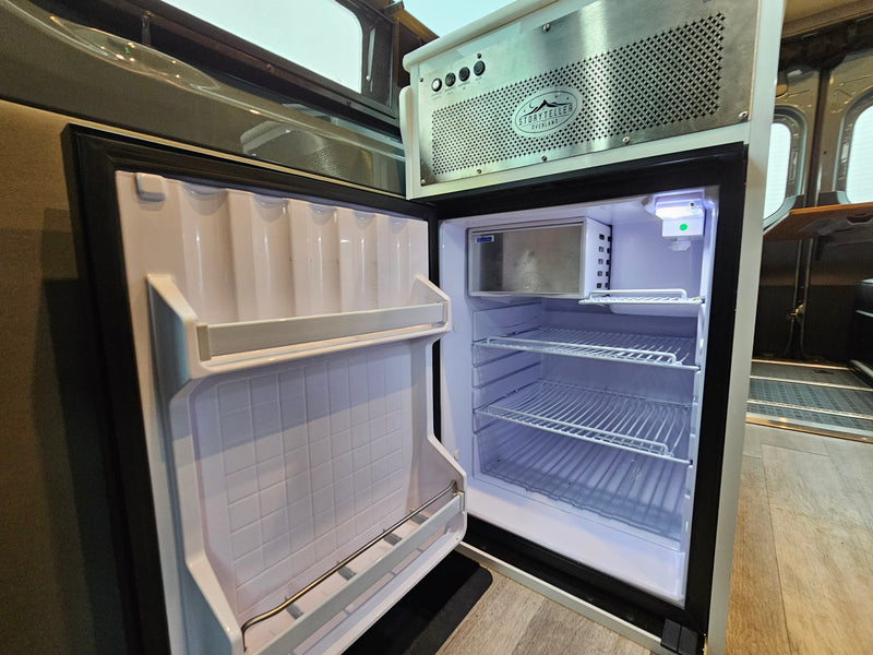  and cup holders visible.|Inside this RV rental: a flexible camper van dinette/bed setup with benches — photo 2