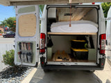 Open rv rental rear reveals bed, organized storage bins & door pockets. Ideal for van life adventures.