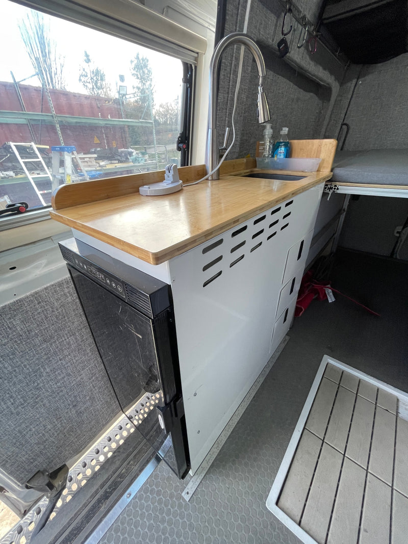  and modular grey bed cushions for comfortable travel.|Inside a functional RV rental: compact kitchenette — photo 8