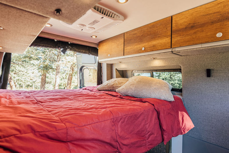  parked outdoors.|Grey Storyteller Overland camper van parked on a scenic road. An RV rental ideal for your next overlanding adventure.|Cozy RV rental interior with living space — photo 6