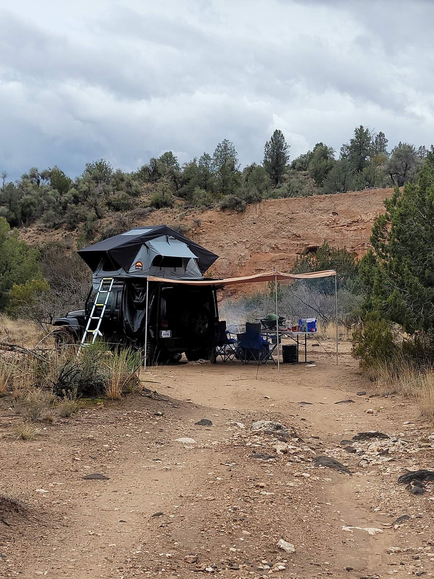  hilly terrain. Your next outdoor adventure or scenic RV rental trip awaits!|Black Jeep with a deployed rooftop tent & ladder — photo 4