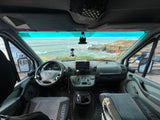 RV rental interior: driver's seat view of a stunning ocean vista from a Mercedes van. Coastal cliffs and dashboard visible.