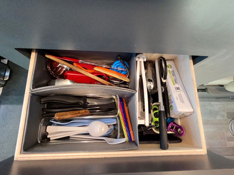 This RV rental kitchen drawer is neatly organized with a variety of utensils, including knives, spatulas, forks, and straws.