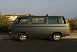 Classic grey VW Vanagon RV, a timeless choice for your next rv rental. Parked on a street near houses.