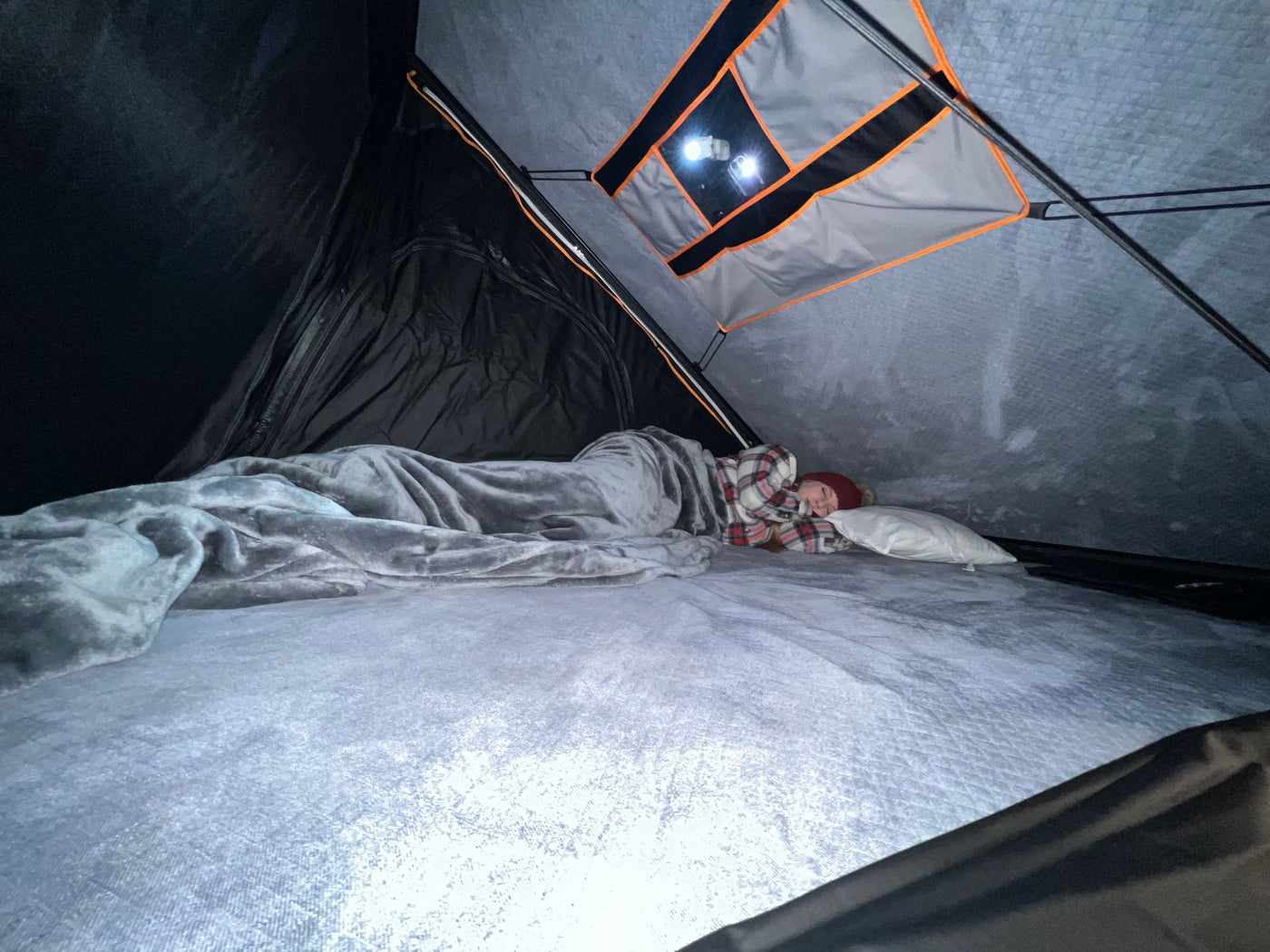  perfect for unique RV rental camping adventures.|Inside a cozy RV rental: a person sleeps soundly on a plush bed under a blanket — photo 2