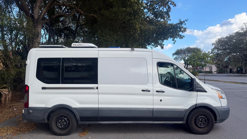  ideal for outdoor showers or changing.|Cozy bed in an RV rental with wooden interior and overhead cabinets. Ready for a comfortable road trip.|Inside an rv rental: rear view of a compact camper van with a toilet — photo 10