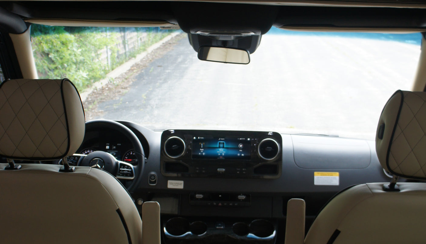 Modern RV rental interior: dashboard with infotainment, steering wheel, and comfortable front seats ready for a journey.