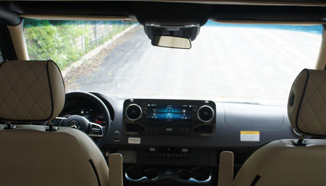 Modern RV rental interior: dashboard with infotainment, steering wheel, and comfortable front seats ready for a journey.