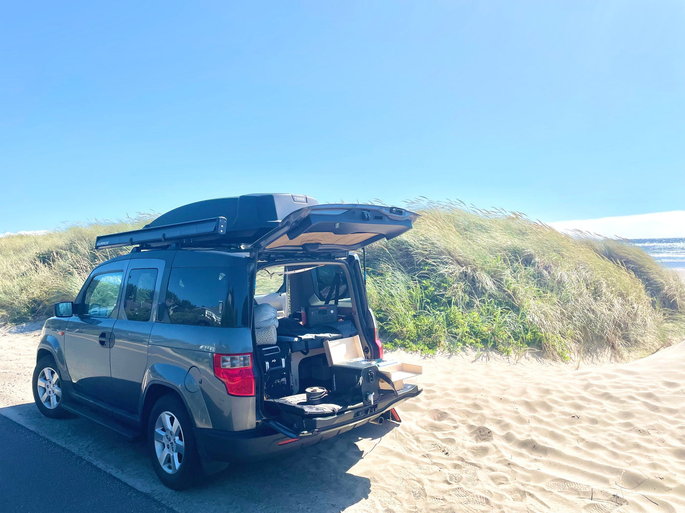 Modified Honda Element with camping gear and roof box at the beach. Ideal for a compact RV rental road trip. — photo 4