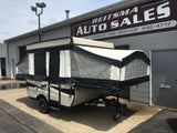A Palomino pop-up camper, suitable for RV rental, is parked outside Reitsma Auto Sales.
