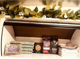 RV rental: A well-stocked shelf with Act II popcorn, assorted coffee, trail mix, and neatly folded towels. A garland adorns the top.