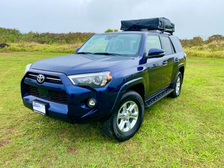Explore with this blue Toyota 4Runner SUV, featuring a rooftop tent for your next RV rental camping trip.
